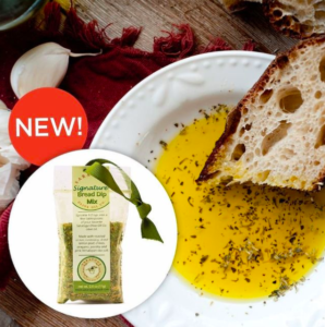 new dip mix packets with a backround of olive oil in a bowl with a piece of bread 